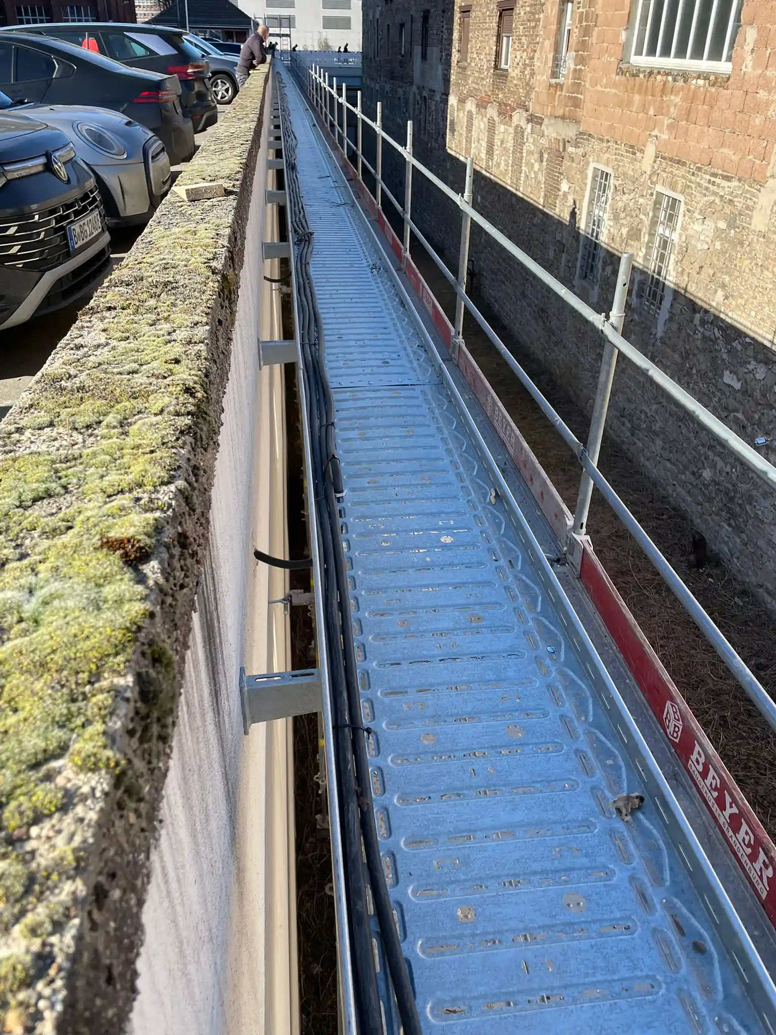 Kabelkanal an einer Mauer entlang der Stellplätze einer Baugenossenschaft in Berlin