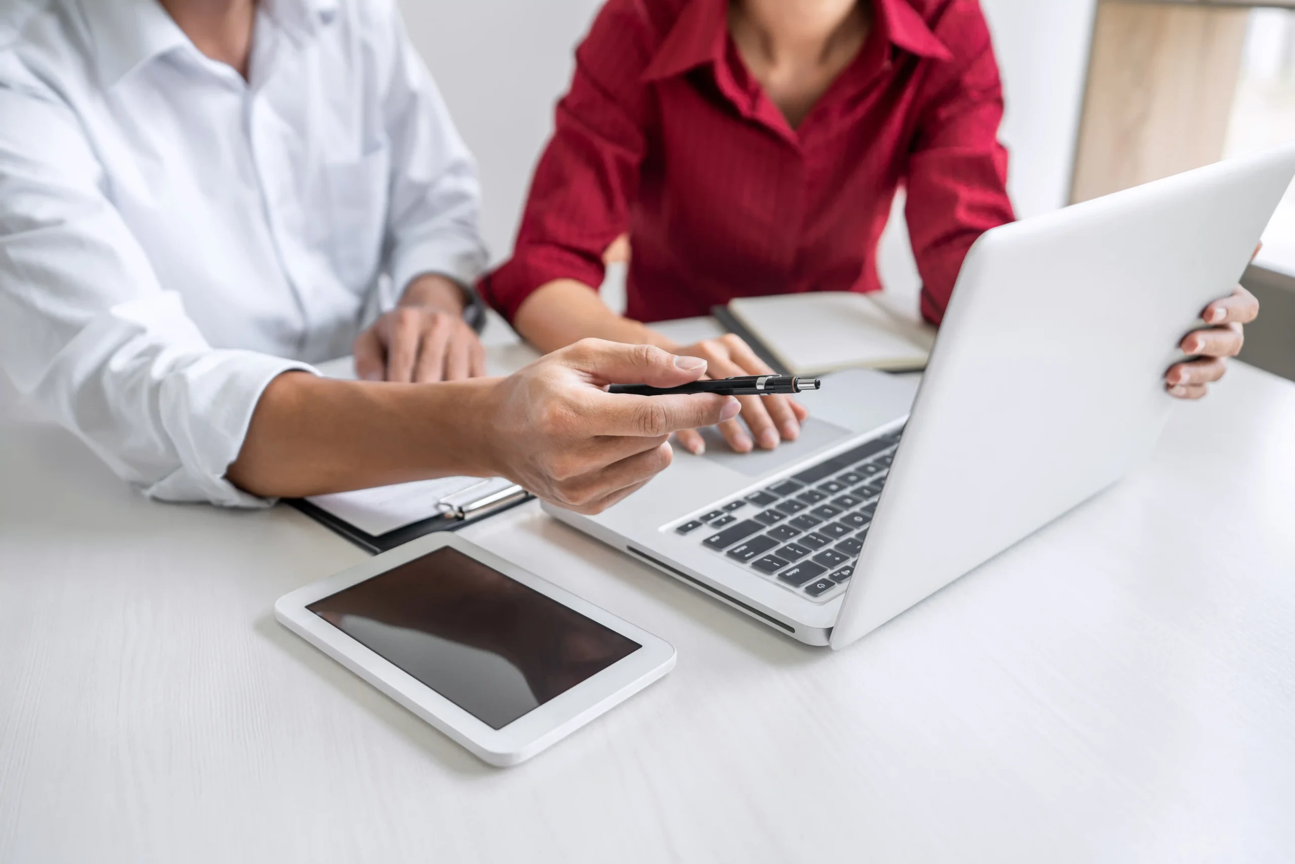 Zwei Personen besprechen Fördermöglichkeiten für Ladeinfrastruktur am Laptop